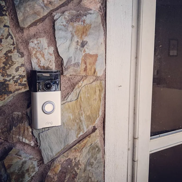 Video doorbell mounted on a stone wall beside a front door