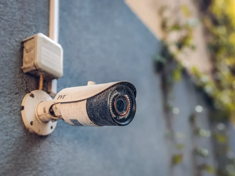 Surveillance camera mounted on a building wall above a pedestrian street
