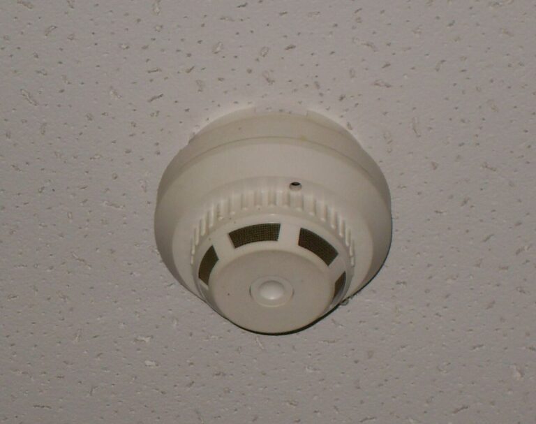 White round smoke detector mounted on a textured ceiling