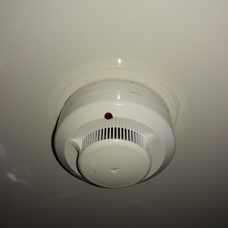 A round smoke detector mounted on a ceiling